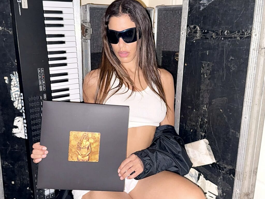 Marina Satti holding the YENNA gatefold vinyl sleeve