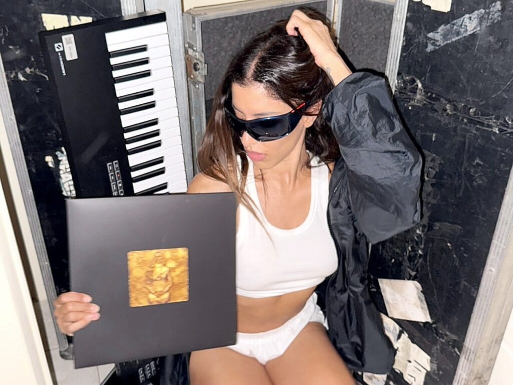 Marina Satti with the YENNA vinyl, hand in her hair