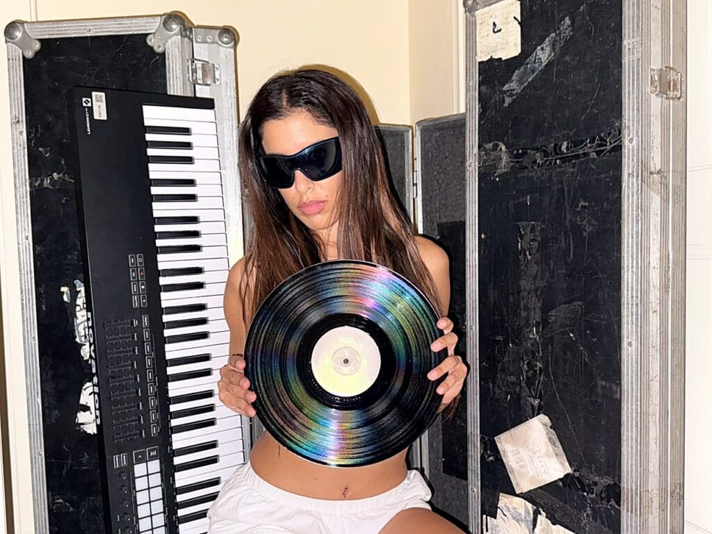 Marina Satti holding the YENNA vinyl record up to the light
