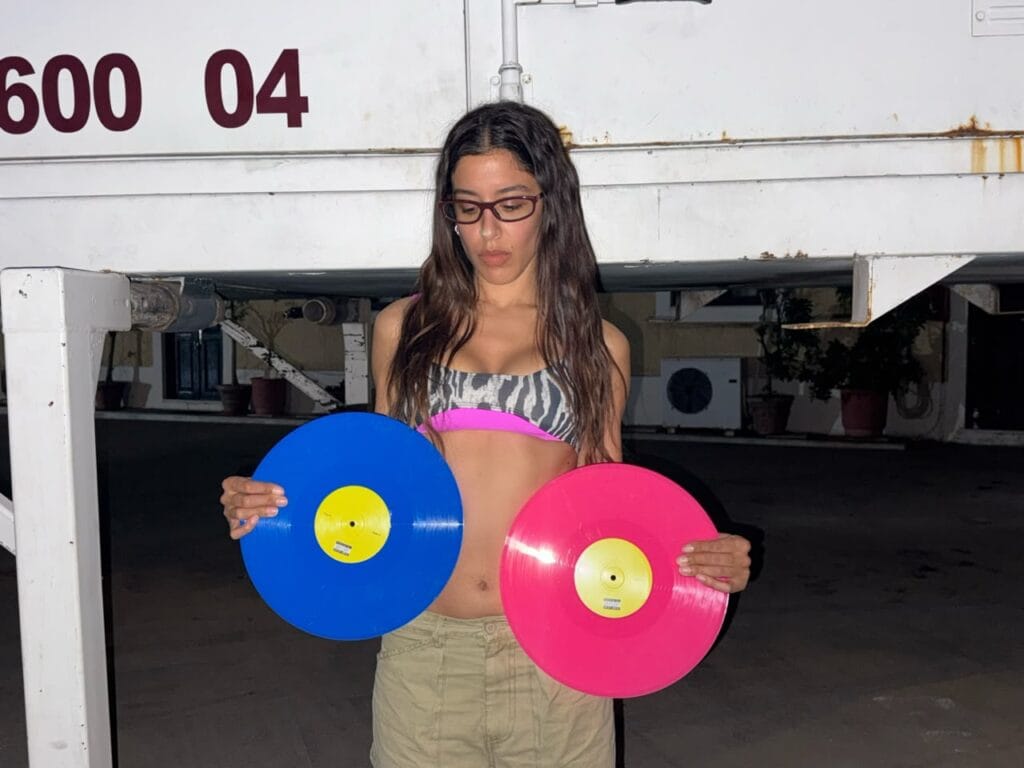 Marina Satti holding the blue P.O.P. and pink POP TOO vinyl records
