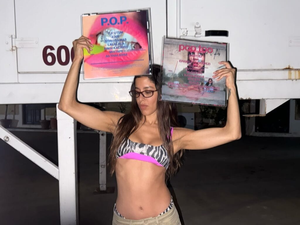 Marina Satti holding up the P.O.P. and POP TOO album sleeves